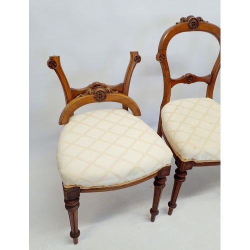 1331 - A set of four Victorian walnut dining chairs with carved backs and fluted tapered supports