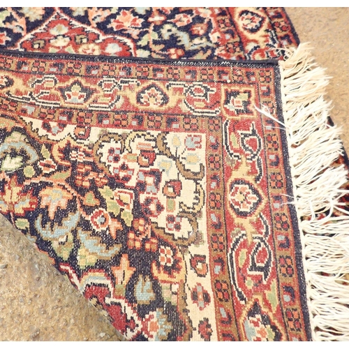 1360 - A small Persian rug with medallion design on blue floral ground 93 x 62cm