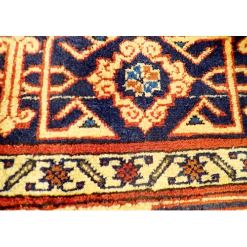 1365 - A Turkmanistan Persian large carpet with geometric and stylised floral decoration on a cream ground ... 