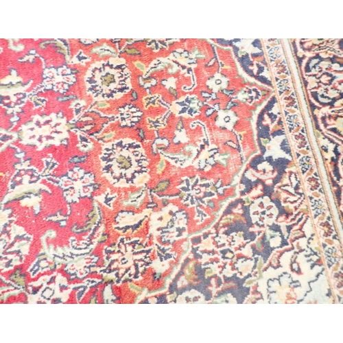 1423 - A Persian rug with blue medallion on a red ground 259 x 141cm