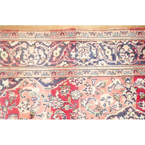 1423 - A Persian rug with blue medallion on a red ground 259 x 141cm