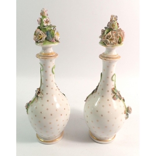 186 - A pair of 19th century porcelain bottles and stoppers with floral encrusted decoration, 25cm tall