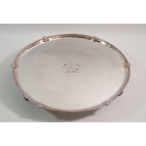 253 - A silver plated on copper circular tray on scroll feet, 32cm diameter