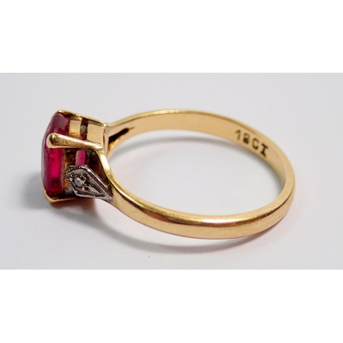 369 - An 18 carat gold ruby ring on diamond chip shoulders, size L, 2.5g