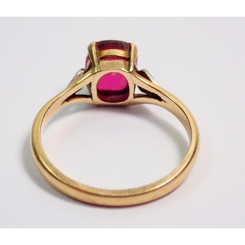 369 - An 18 carat gold ruby ring on diamond chip shoulders, size L, 2.5g