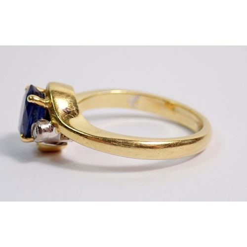 383 - An 18 carat gold ring crossover set oval cut sapphire flanked by two small diamonds, size L to M, 5.... 