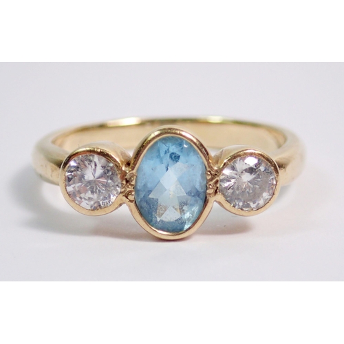 384 - A 9 carat gold ring collet set blue topaz flanked by white stones, size O, 3.5g