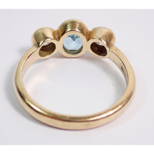 384 - A 9 carat gold ring collet set blue topaz flanked by white stones, size O, 3.5g