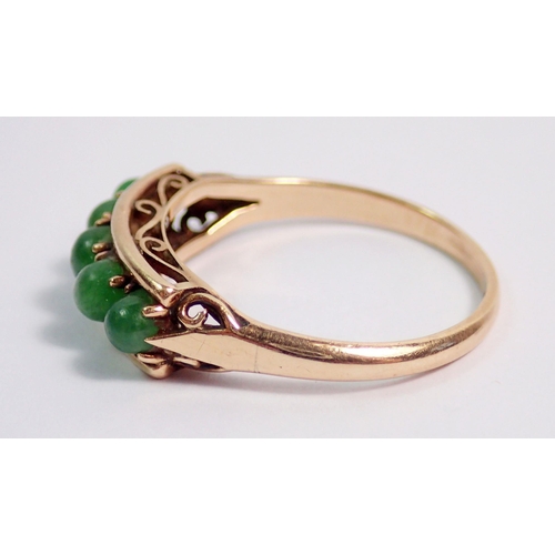 389 - An 18 carat gold ring set five cabochon cut green stones, size L to M, 2.2g