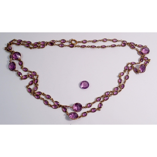 452 - An Edwardian long amethyst paste and yellow metal necklace with single spare stone, 140cm