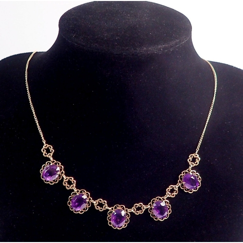 478 - A 9 carat gold necklace suspended five oval cut amethysts within scrollwork surrounds, 44cm, 9g