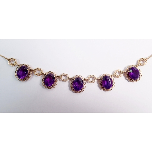 478 - A 9 carat gold necklace suspended five oval cut amethysts within scrollwork surrounds, 44cm, 9g