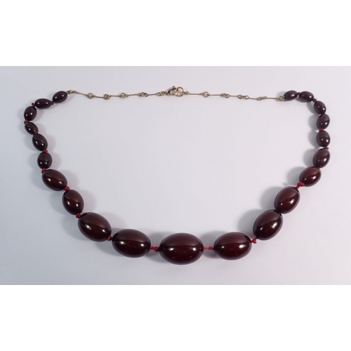 559 - A cherry amber necklace, largest bead 3cm wide x 2cm, 58cm total length of necklace, 52g