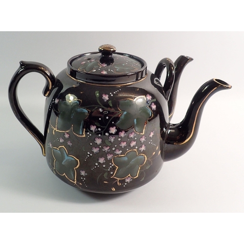 9 - A Victorian black painted floral two spouted teapot, 19cm tall