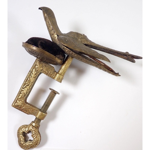 942 - An antique brass sewing clamp with pin cushion and bird surmount, 13cm tall