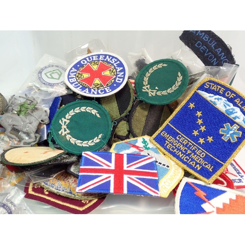 973 - A box of collectables including military interest badges, buttons, replica medals, ambulance and par... 