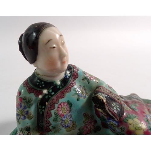 121 - A Chinese figure of a woman reclining with a fan on a leaf - head repaired, 14cm long