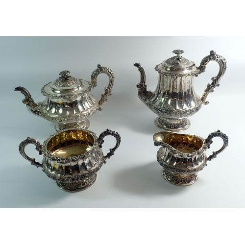 276 - A Georgian silver four piece tea service with rose finials and fluted body, with further floral band... 