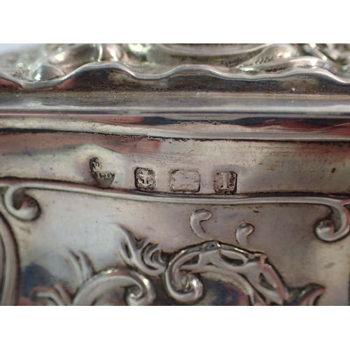 290 - A silver bombe form embossed tea caddy, 12cm tall, Birmingham 1910, makers mark rubbed, 303g