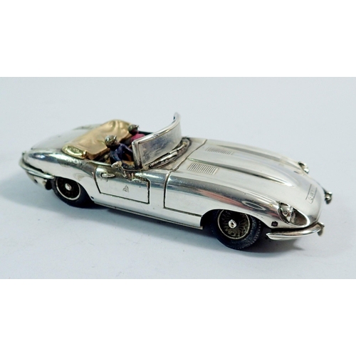 297 - A silver model E Type Jaguar convertible by Gordon Yates with two enamel figures, set ruby rear ligh... 