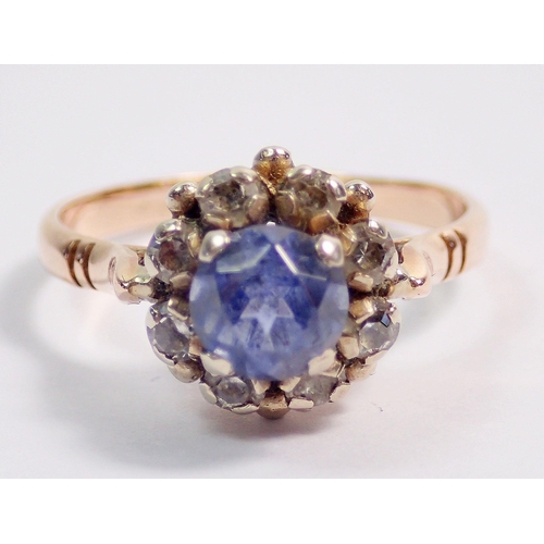 338 - A 14 carat gold ring set pale blue sapphire within white stone surround, size O to P