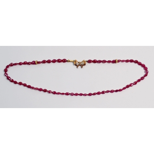 384 - A ruby bead necklace with 9 carat and chip diamond bow clasp, 40cm long