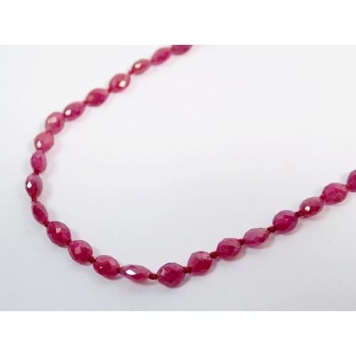 384 - A ruby bead necklace with 9 carat and chip diamond bow clasp, 40cm long