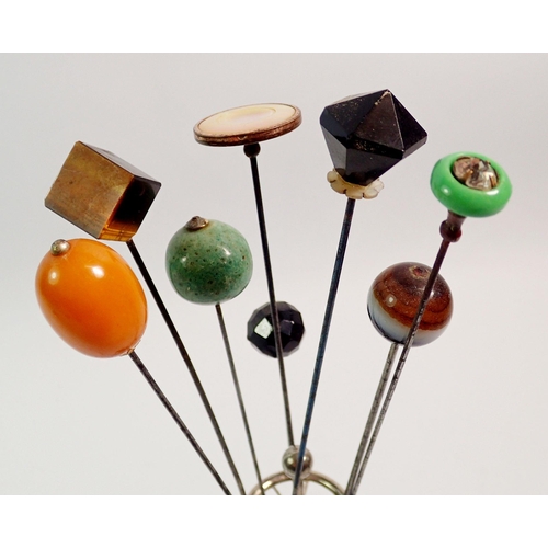 421 - A collection of beaded hat pins in silver plated circular stand including amber