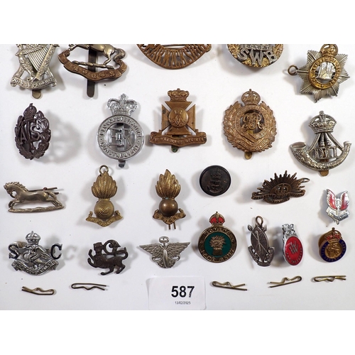 587 - A quantity of military cap badges