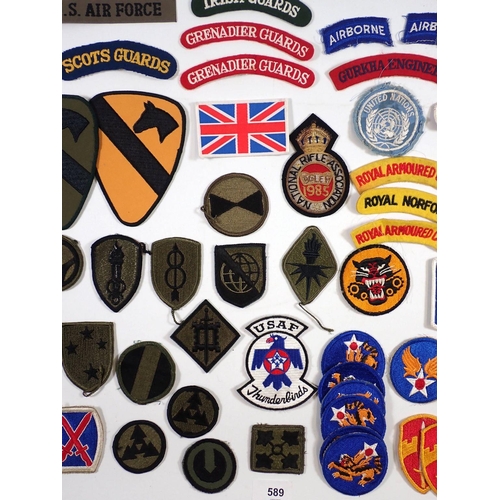 589 - A selection of military cloth shoulder titles etc.