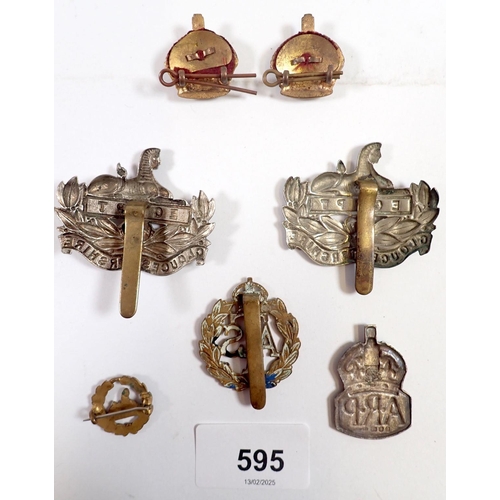 595 - A group of military cap badges and pair of WWI officers crown insignia rank pips