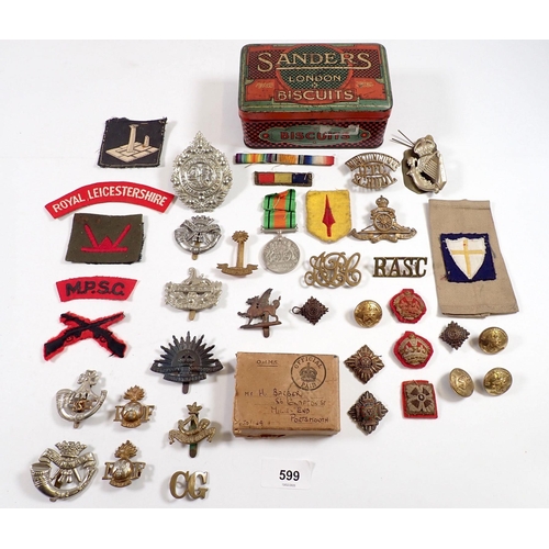 599 - A tin of various items of Military insignia - cloth formation patches, metal badges, the 8th Royal I... 