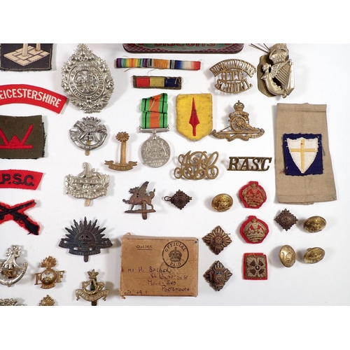 599 - A tin of various items of Military insignia - cloth formation patches, metal badges, the 8th Royal I... 