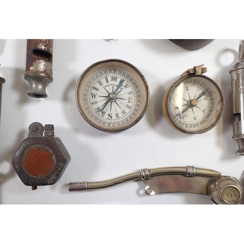 605 - A selection of military whistles, compasses etc.