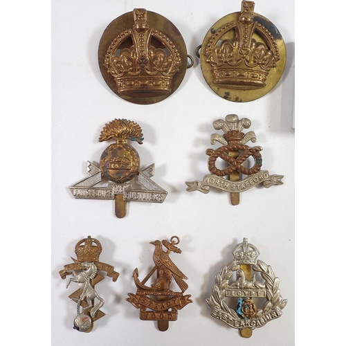 606 - A quantity of cap badges, buckles etc.