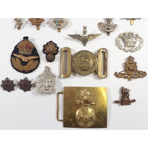 606 - A quantity of cap badges, buckles etc.