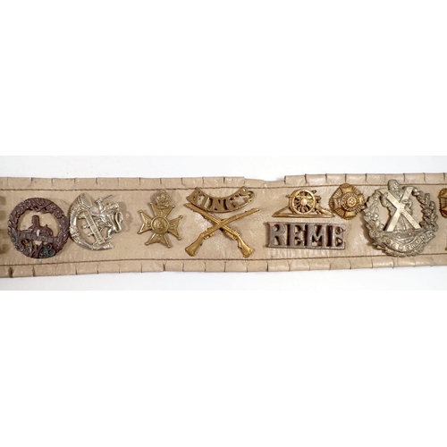 615 - A Military trophy belt with 25 cap badges