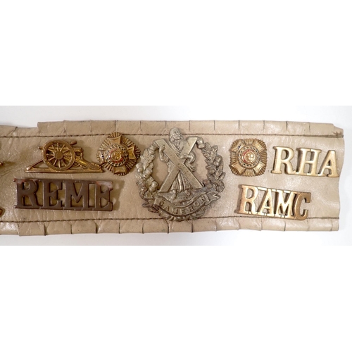 615 - A Military trophy belt with 25 cap badges