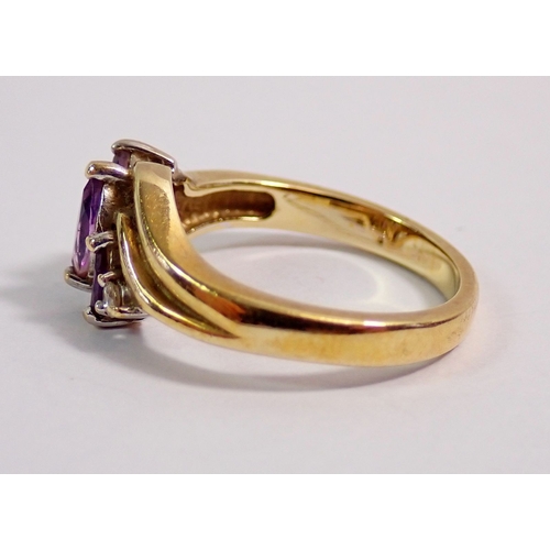 296 - A 9 carat gold crossover ring set three amethysts and two chip diamonds, 3g, size J to K