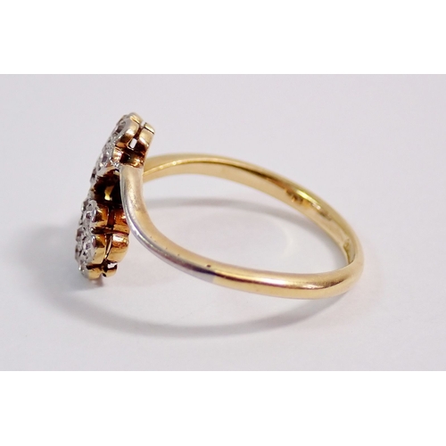 307 - An Edwardian 9 carat gold ring crossover set two flower form diamond clusters, size K-L, 2.1g, hallm... 
