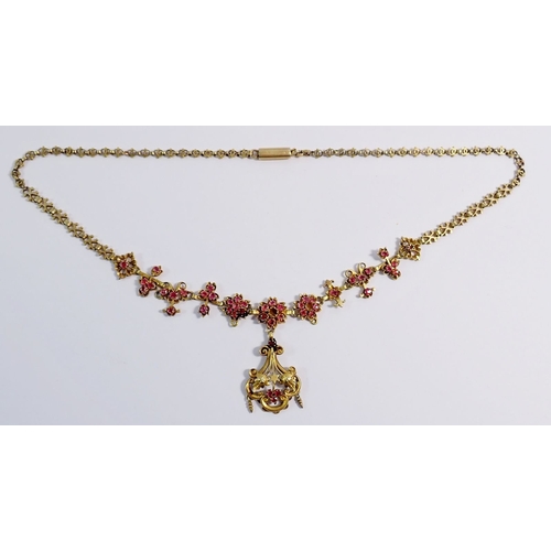 321 - A Victorian gilt metal necklace in the Aesthetic style with pendant drop on ornate chain, all set pi... 
