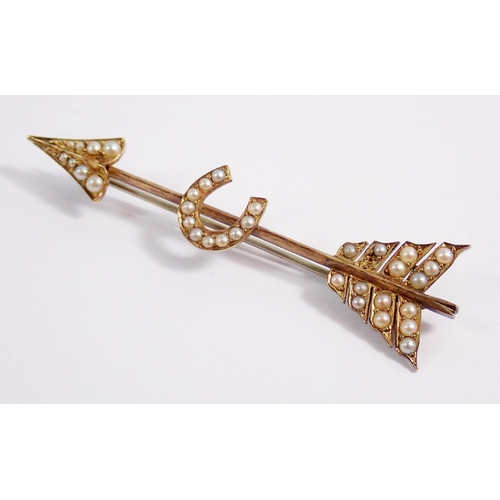 325 - An Edwardian 18 carat gold pearl set horseshoe  and arrow bar brooch, (not marked but tested) 5.7cm ... 