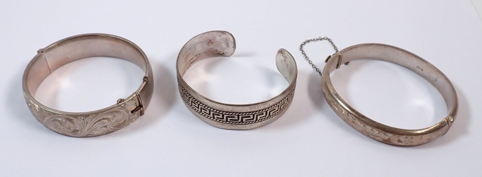 Two silver hinged bangles and an 800 standard silver bracelet decorated ...