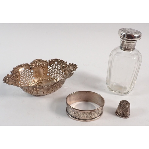 172 - A silver pierced bon bon basket - a/f, a silver thimble, silver topped toiletry bottle and napkin ri... 