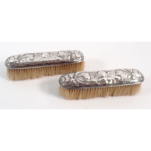 175 - A pair of Victorian silver brushes embossed angel heads