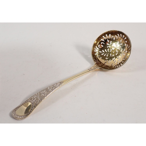 195 - A Victorian silver gilt sugar bowl with repouse decoration of foliage and shells and matching sifter... 