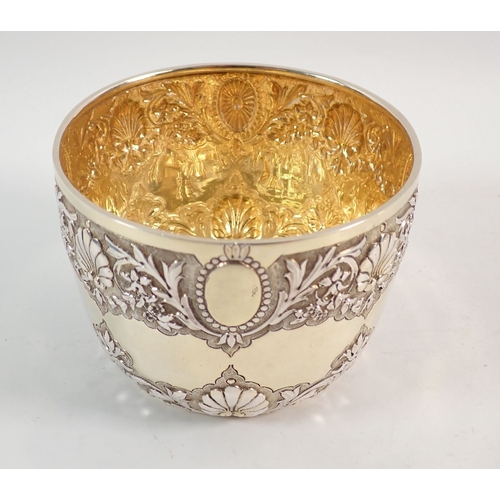 195 - A Victorian silver gilt sugar bowl with repouse decoration of foliage and shells and matching sifter... 