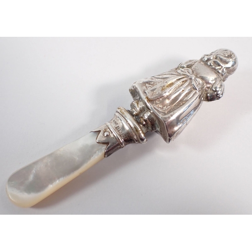 201 - A silver teether in the form of a girl, with mother of pearl handle, 10cm long by W H Collins & Co B... 