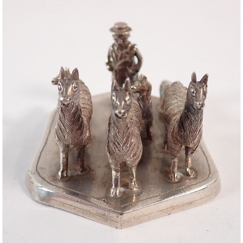 202 - A South American white metal group of llamas and dog with farmer, 7.5cm long, 140g