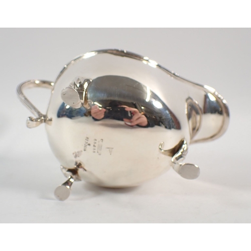 209 - A silver sauce boat with three foliate pad feet, Walker & Hall, Sheffield 1926, 148g